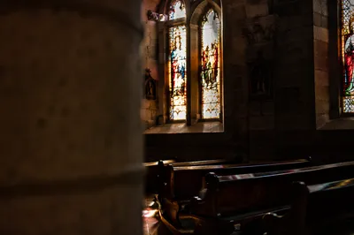 Sunlit Church Pews and Stained Glass