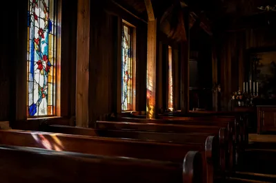 Sunlit Stained Glass Over Chapel Pews
