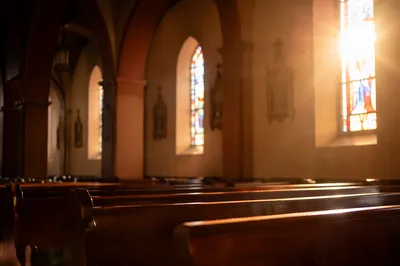 Sunlit Church Pews with Stained Glass