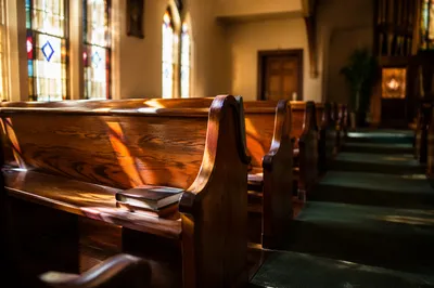 Sunlit Church Pews with Stained Glass