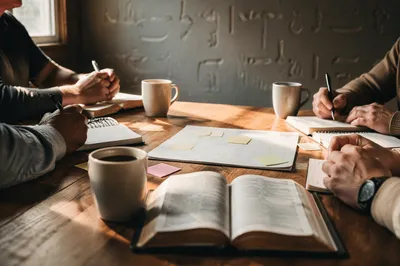 Church Staff Planning Meeting at Wooden Table