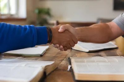 Warm Church Welcome Handshake at Fellowship Table