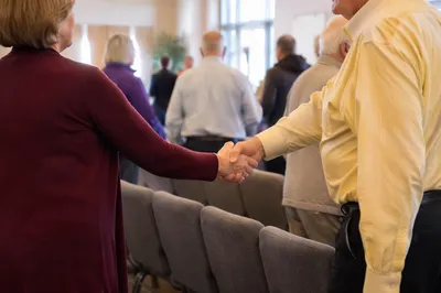 Warm Church Welcome Handshake in Fellowship Hall