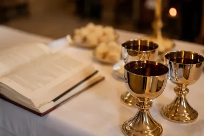 Communion Table with Chalices Bread and Open Bible