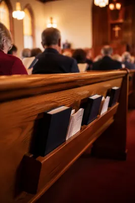Hymnals Resting in Warm Church Pew