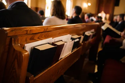 Hymnals Resting in Warm Church Pew