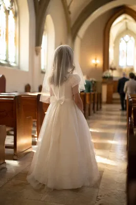 Child in White Dress at Communion