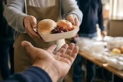 Hands Sharing Food in Outreach Ministry