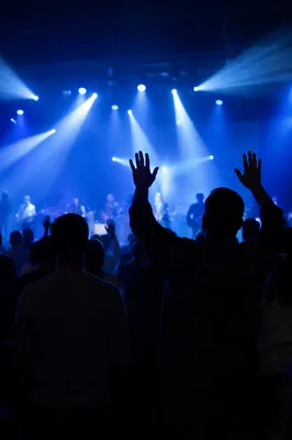 Raised Hands in Blue Worship Lights