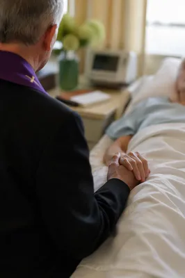 Hospital Chaplain Praying at Patient Bedside