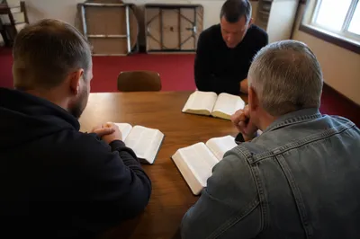 Men Sharing Bible Study in Fellowship Room