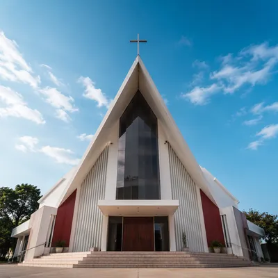 Modern Church Exterior With Cross Under Blue Sky