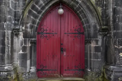 Crimson Arched Door of Historic Stone Chapel