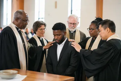 Clergy Praying Over Man in Chapel