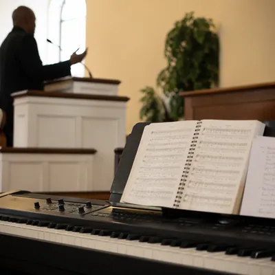 Pastor Preaching Beside Chapel Worship Keyboard