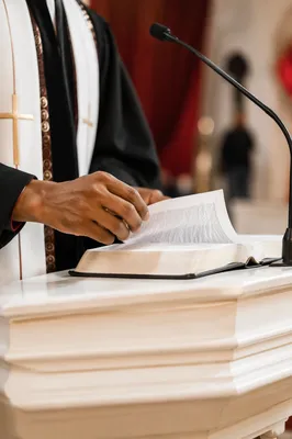 Pastor Hands Turning Scripture at White Pulpit