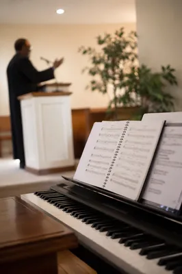 Pastor Preaching Beside Hymnal in Chapel