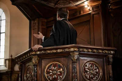 Pastor Preaching at Ornate Wooden Pulpit