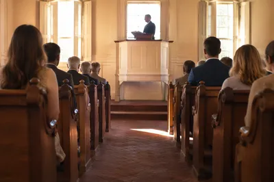 Pastor Preaching in Historic Wooden Chapel