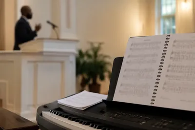 Pastor Preaching Beside Chapel Keyboard
