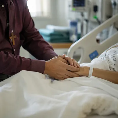 Pastor Comforting Hospital Patient at Bedside