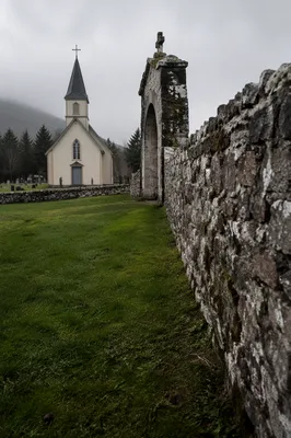 Weathered Wooden Chapel Behind Stone Wall