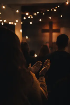 Raised Hands in Dim Chapel Light