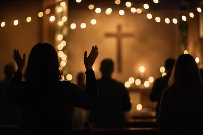 Silhouettes in Dim Chapel with Candle Bokeh