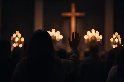 Silhouetted Figure Facing Cross and Warm Lights