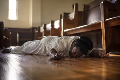 Woman Praying Prostrate in Church Interior