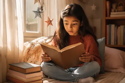 Curious Girl Reading on Window Seat