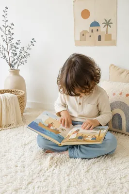 Child Reading Picture Book on Rug