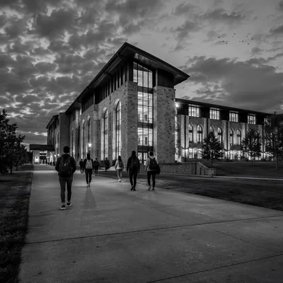 Students Walking to College Building at Dusk