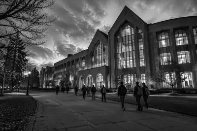 Students Walking to College Building at Dusk