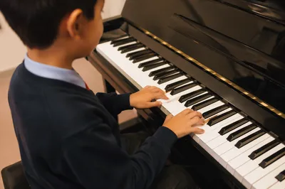 Young Student Practicing Piano During Lesson