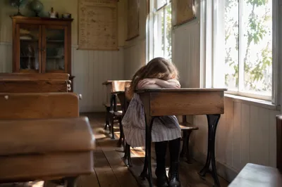 Quiet Student in Sunlit Vintage Classroom