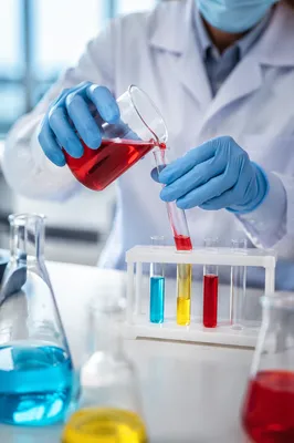 Student Pouring Colorful Liquids in Science Lab