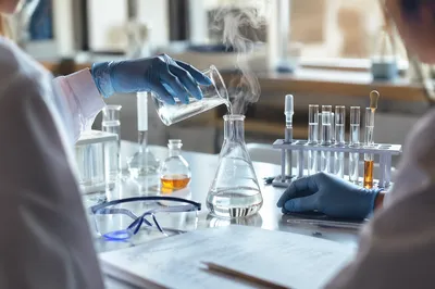 Students Pouring Beaker in School Chemistry Lab