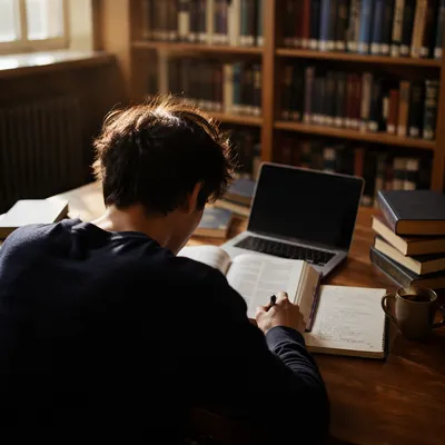 Focused Student Studying at Library Desk