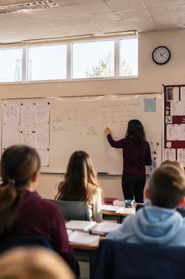 Teacher Writing on Classroom Whiteboard