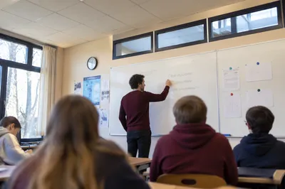Teacher Writing on Classroom Whiteboard