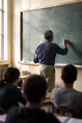 Teacher Writing on Classroom Chalkboard