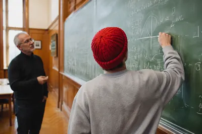 Student Writing on Classroom Chalkboard