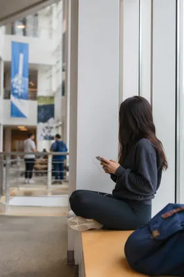 Student Relaxing in Modern University Atrium