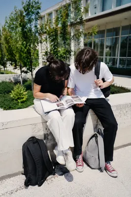 Students Reading Guidebook on Modern Campus