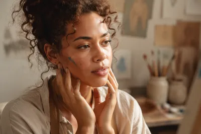 Focused Young Woman Artist in Sunlit Studio