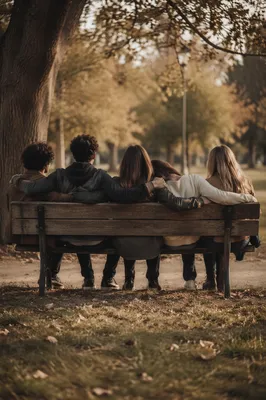 Friends Embracing on Park Bench at Sunset