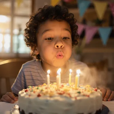 Excited Child Blowing Birthday Cake Candles