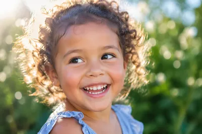 Giggling Child in Sunlit Garden Portrait