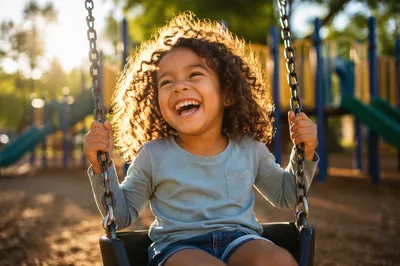 Giggling Child on Playground Swing
